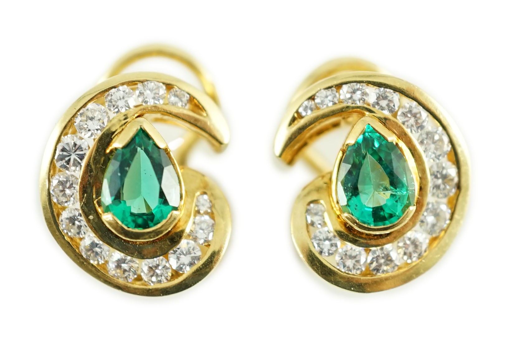 A modern pair of gold (tests as 18ct), emerald and diamond set scrolling cluster earrings